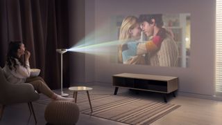 LG PF600U projector/lamp lifestyle image with woman in seat watching movie 