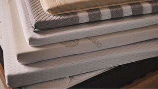 A stack of the best mattress toppers on top of a mattress