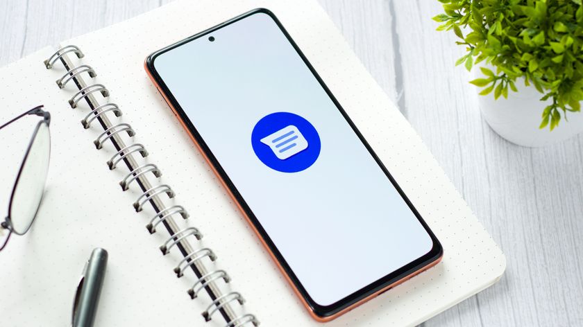 A phone resting on a notebook showing the Google Messages logo