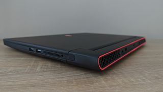 En Alienware M15 R7 ligger stängd på ett ljust träfärgat skrivbord.