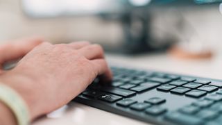 Fingers typing on a computer keyboard.