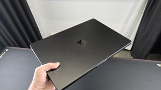 En 16-tommers MacBook Pro med M4 Pro-brikke holdes i en hånd.