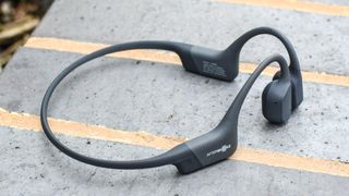 Shokz OpenRun headphones on top of a wall