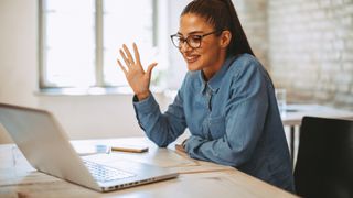 Vrouw zwaait naar laptop in een video-call