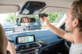 A man adjusting a Nextbase dash cam in a car