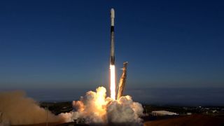 a rocket lifting off in front of a blue sky