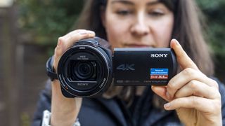 A female photographer holding the Sony AX43 camcorder