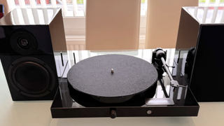 The Pro-Ject Juke Box E1 turntable in black pictured on a table