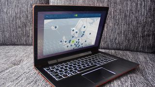 NordVPN körs på en laptop som ligger öppnad i en grå soffa.