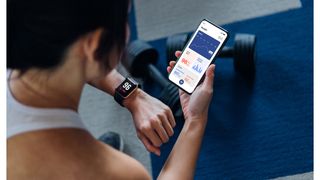 Woman using a workout app and syncing it with her watch