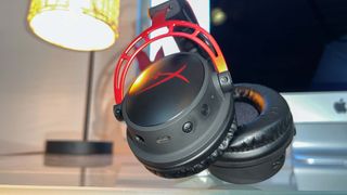 A HyperX Cloud Alpha Wireless gaming headset on a glass desk