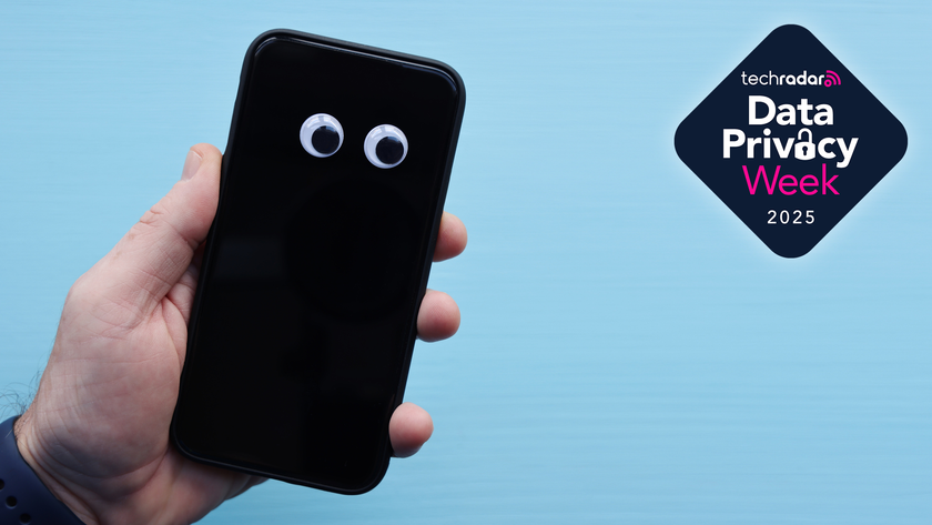 Photograph of a hand holding a smartphone with two googly eyes