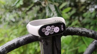 The Xiaomi Smart Band 9 in a green park.