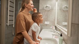 A mom and son brush their teeth before going to bed