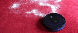 Eufy Robovac 15C Max on a red carpet with flour on the floor