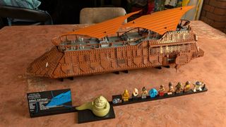 Lego Jabba's Sail Barge, plaque, and minifigures on a dusty desert background