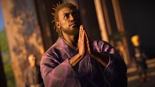 Assassin's Creed Shadows screenshot showing Yasuke kneeling and praying while wearing a traditional purple robe