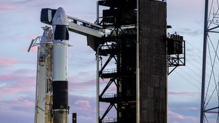 A black and white SpaceX Dragon and Falcon 9 rocket on the launch pad in twilight for the Polaris Dawn mission.