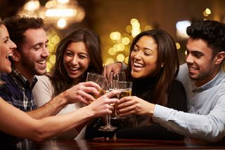 Men and women at a bar with drinks