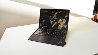 En Lenovo ThinkPad X12 Detachable står öppnad på ett vitt skrivbord.