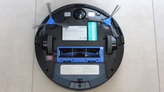 Eufy RoboVac 11S upside down on a tiled floor