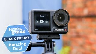 DJI Osmo Action 4 on a selfie stick against a white, blue and brick background. A Tom's Guide badge is in the lower left corner