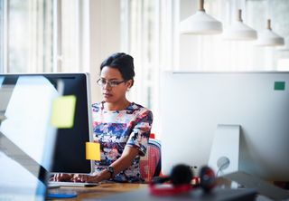 Female office worker working a computer behind a desk