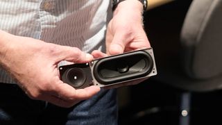 A man holds a speaker unit disconnected from any product, in Samsung's Audio Lab