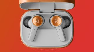 The B&O Beoplay Eleven earphones on orange and red background