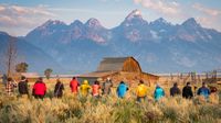 Photographers working in Grand Tetons National Park photographing a barn and mountains