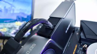 An Nvidia graphics card slotted into a test bench with its power cable in the foreground