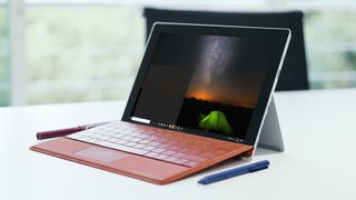 Tablet sitting on desk displaying image of night sky and tent on screen