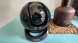 IMOU Rex 3D home security camera on table beside diffuser