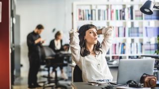 A worker sitting at her desk daydreaming