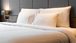 Four white pillows stacked on a luxury mattress