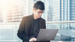 Whitepaper cover with title on block blue background below image of man sat with a laptop in front of high-rise buildings