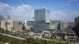 An aerial photo of AMD's campus in Shanghai, showing a large square building covered in reflective glass