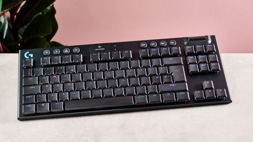 Logitech G915 X on desk with plant and pink wall in background