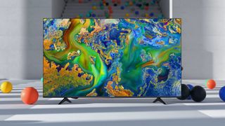 The Hisense U6G ULED TV in a grey room surrounded by coloured balls