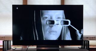 LG C4 OLED TV showing image of woman looking through glasses