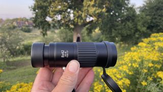 An Opticron Explorer WA ED-R 8x42 monocular held between the author's fingers.