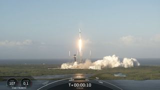 a white and black rocket launches into a blue sky