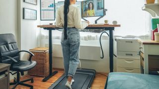 Woman working while walking on an under-desk treadmill