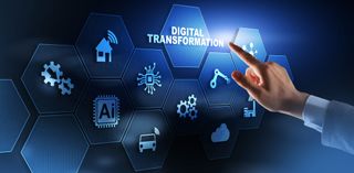 A hand hovering over the word ‘digital transformation’ on a blue background