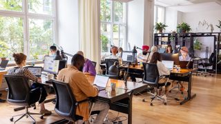 Software developers sitting at desks in an open plan office space.