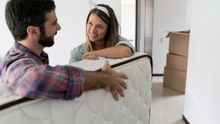 A young couple move a new mattress they bought from Amazon