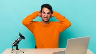 laptop user feeling stressed, anxious or scared, with hands on head