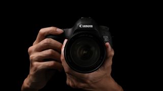 canon eos 5d mark iii in the hand with black background