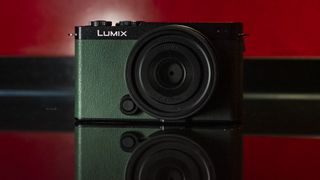 Panasonic Lumix S9 camera in Dark Olive color on a rich red reflective surface