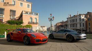 A red Porsche and a silver Porsche parked in a sunny lot